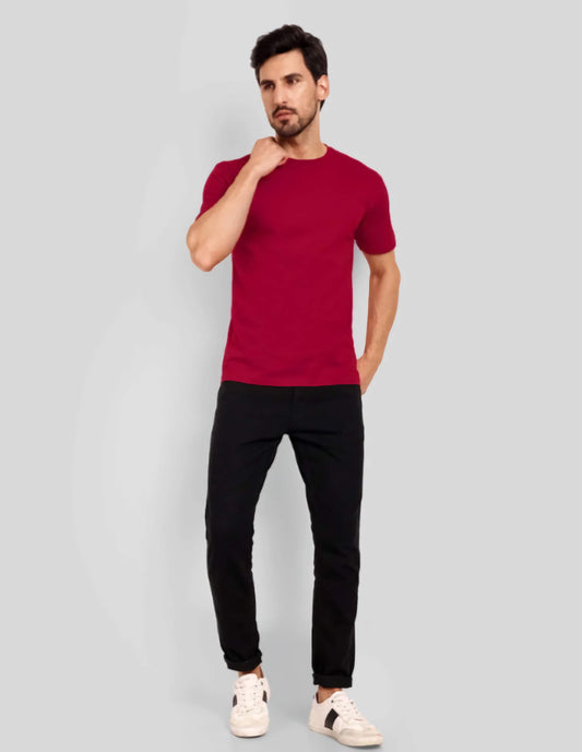 Man wearing a red t-shirt and black pants on a gray background