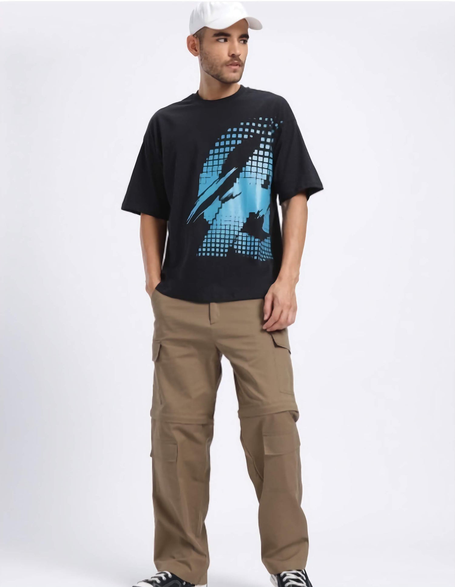 Man wearing a black t-shirt with a marvel captain America graphic design and beige cargo pants on a white background