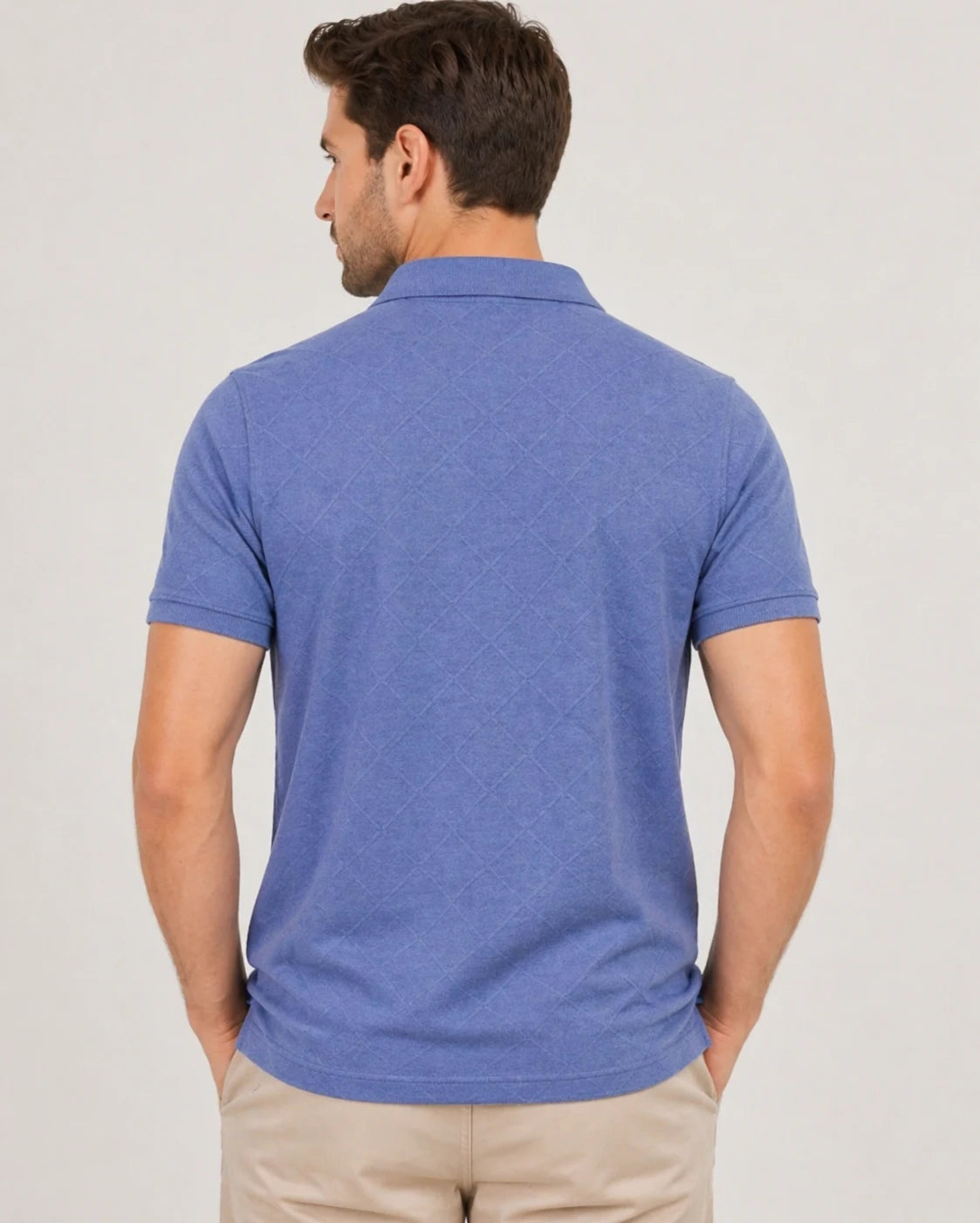 Man wearing a blue 200 gsm polo shirt on a plain background and showing the back of the tshirt
