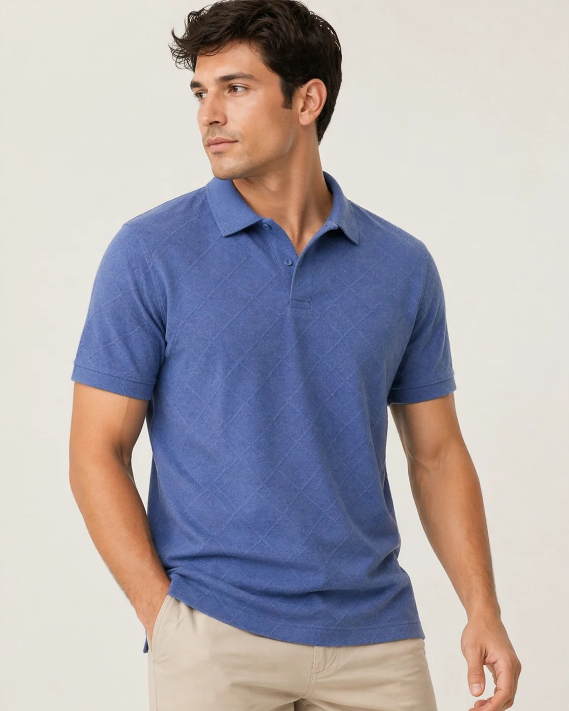 Man wearing a blue polo shirt showingnside angle against a plain background