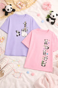 Two t-shirts, one purple and one pink, with panda designs on a soft surface with toys and accessories.