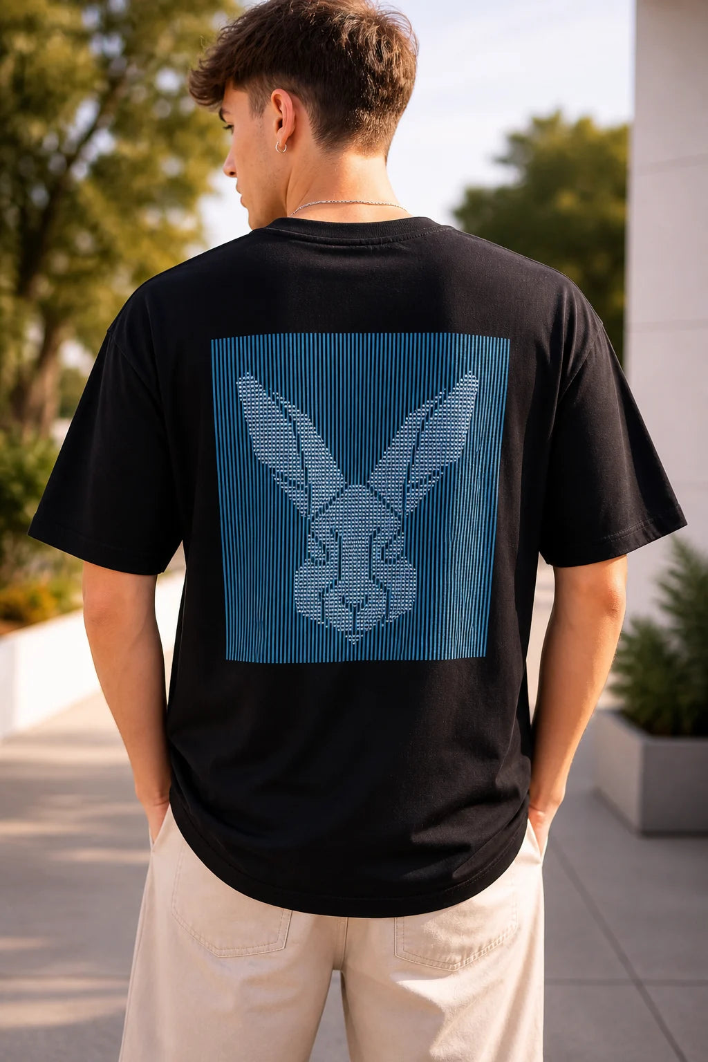 man wearing black oversized t-shirt with minimal rabbit graphic back print 240 GSM cotton India”