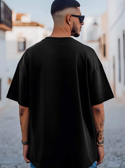 Man wearing a black oversized t-shirt with a blurred background