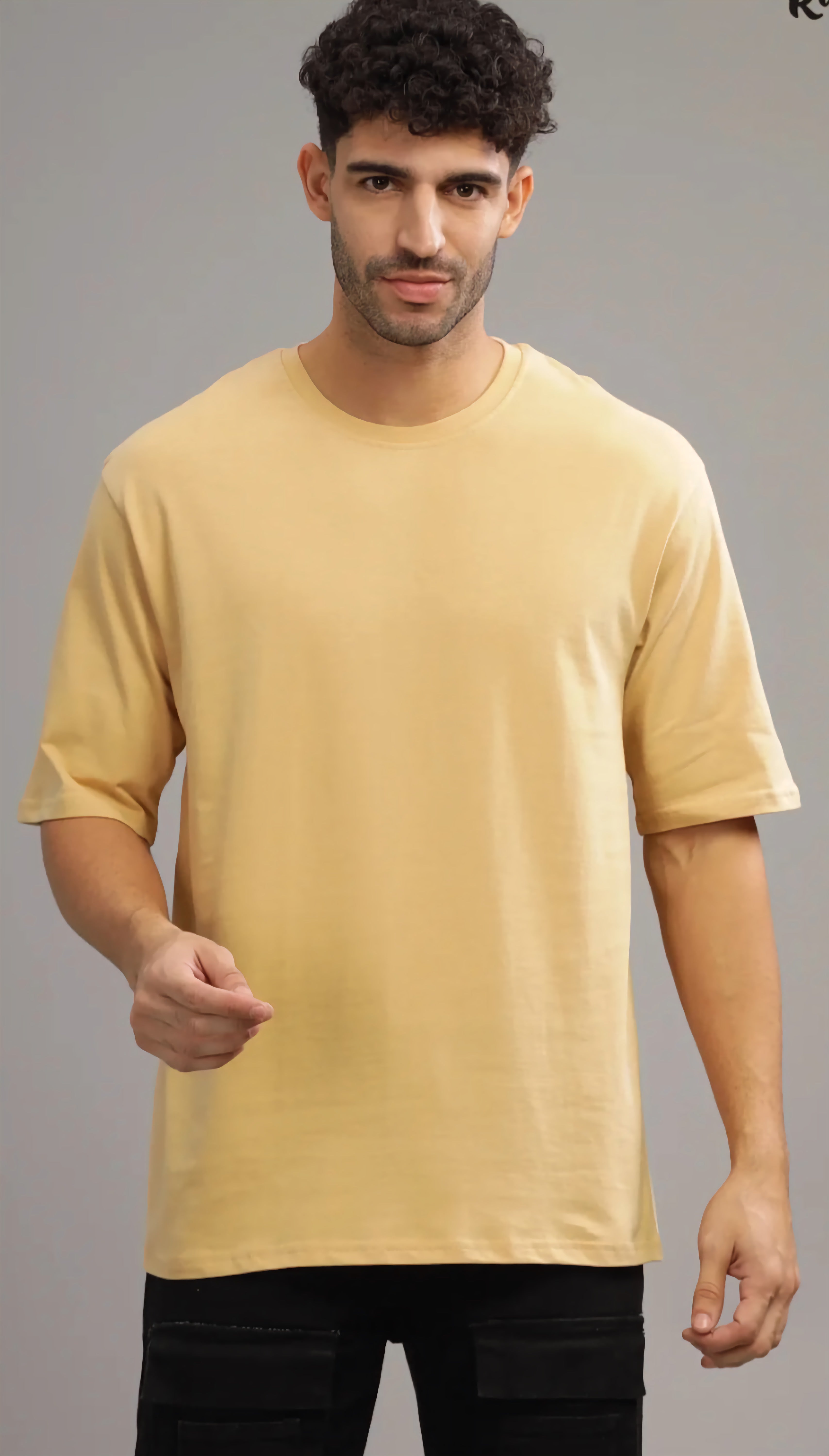 Man wearing a plain yellow t-shirt against a gray background