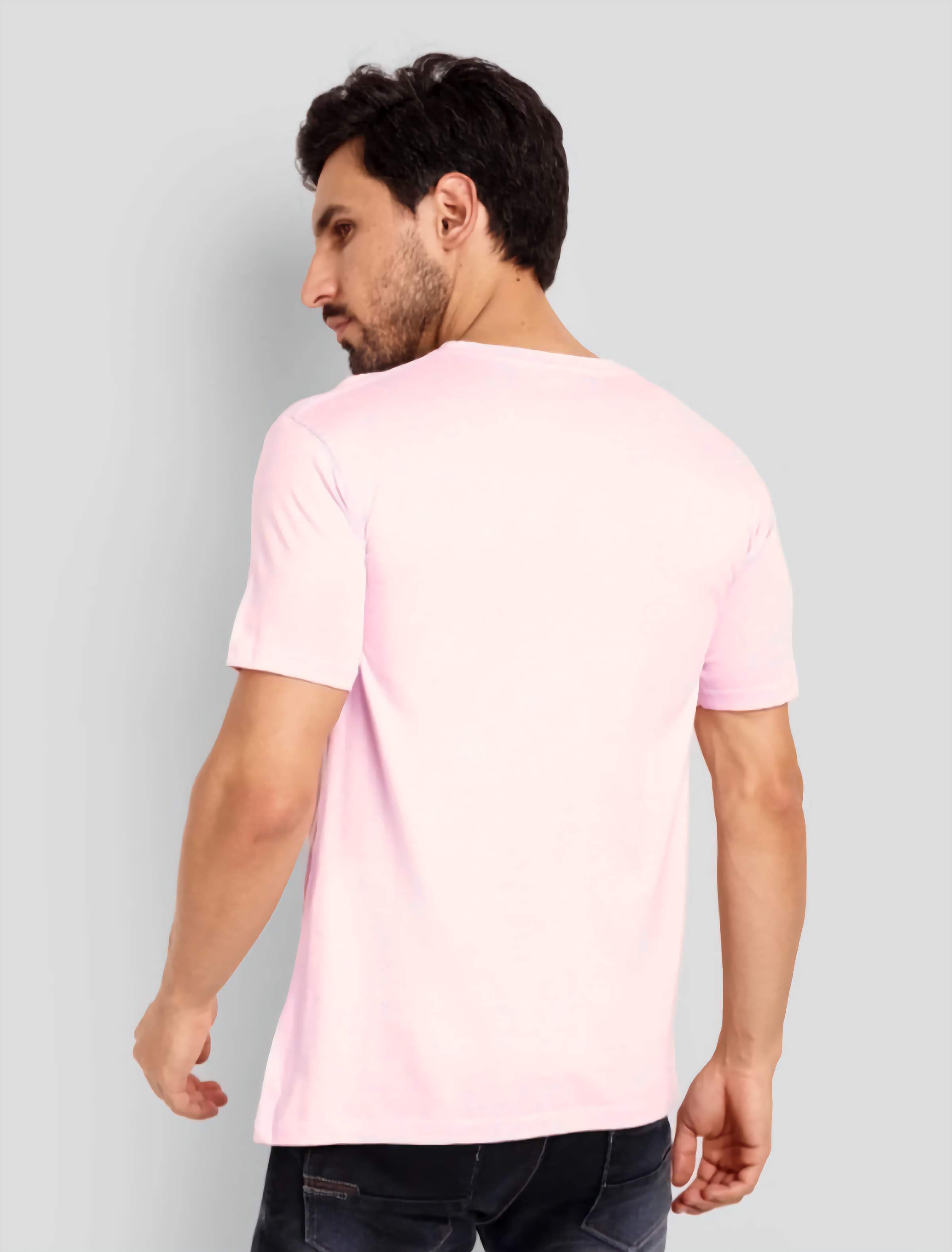 Man wearing a light pink t-shirt against a gray background