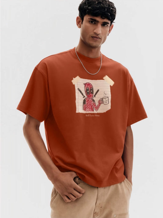 Person wearing a brown t-shirt with dead pool graphic design and beige pants on a white background