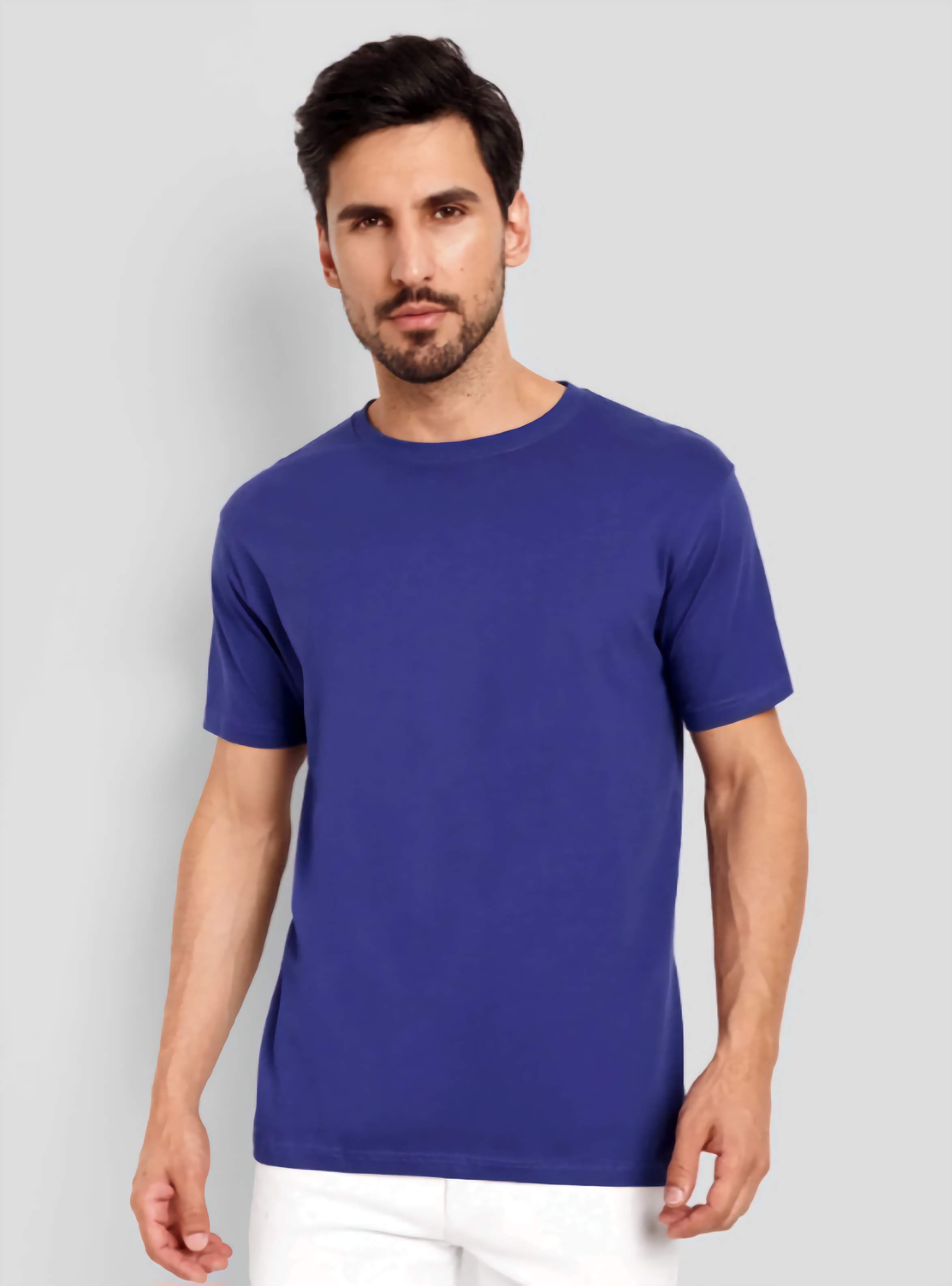 Man wearing a blue t-shirt against a gray background