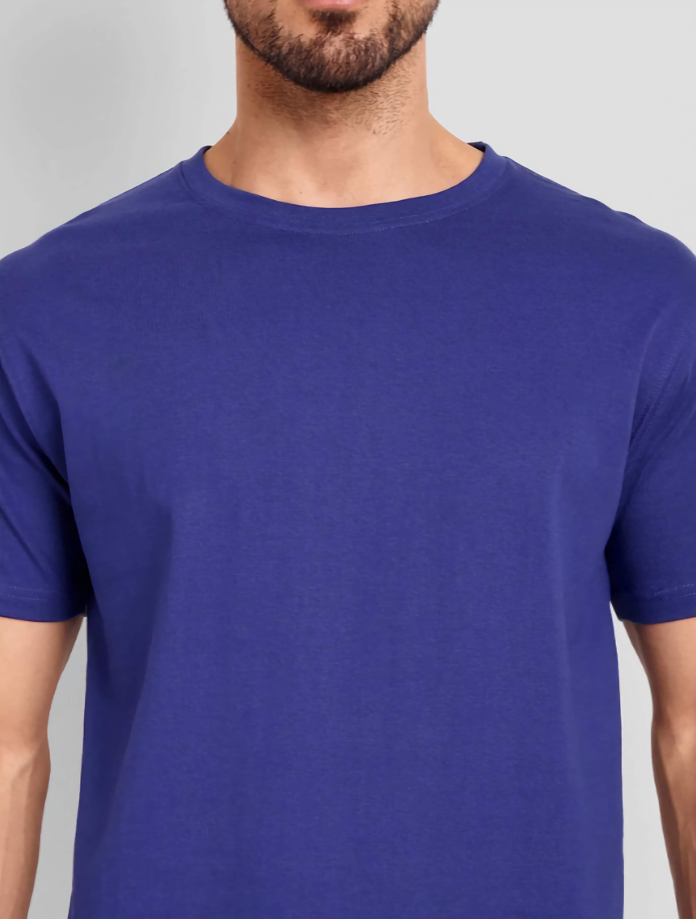 Man wearing a blue t-shirt against a gray background