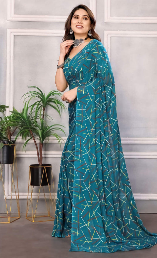 Woman wearing a teal saree with a geometric pattern in an indoor setting.