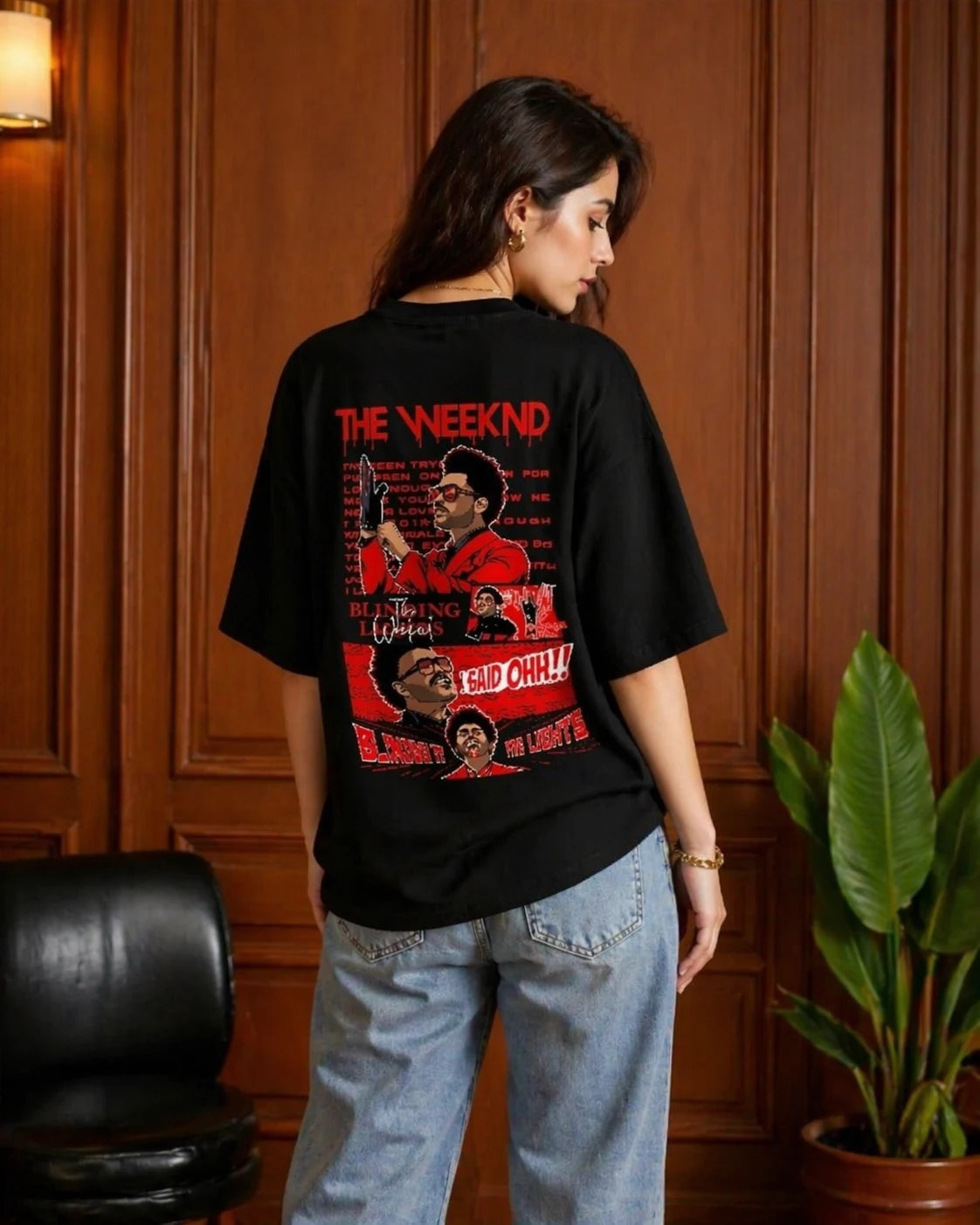 Person wearing a black t-shirt with red graphic design in an indoor setting